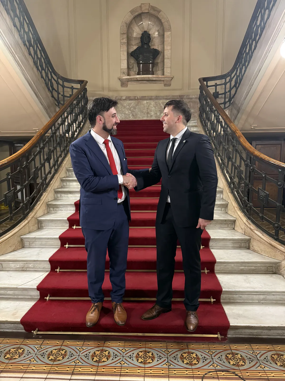 Greeting between representatives of two organizations on an institutional staircase